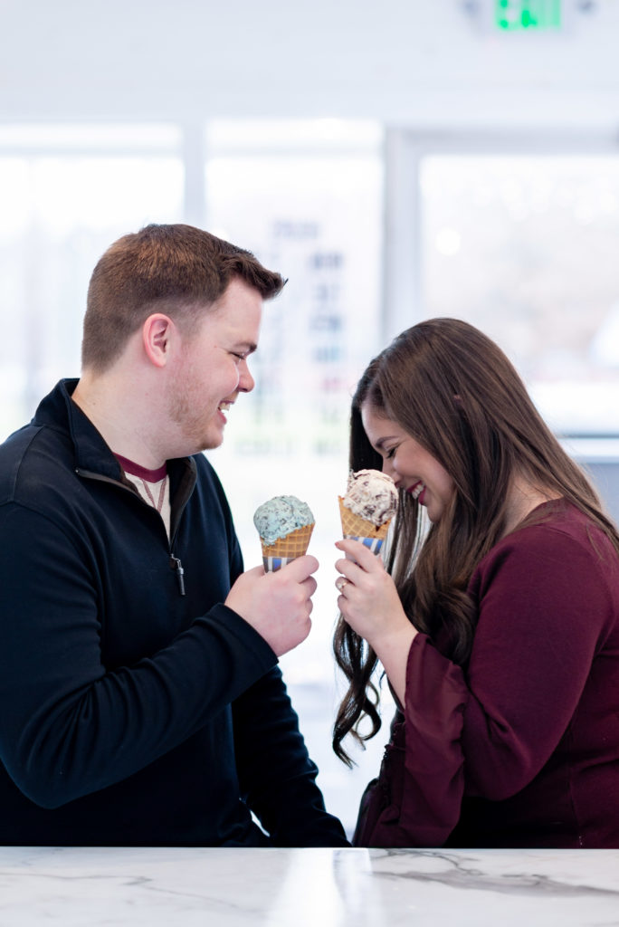 Location of engagement session matters.Gorgeous couple enjoying one another and ice cream together celebrating their engagement